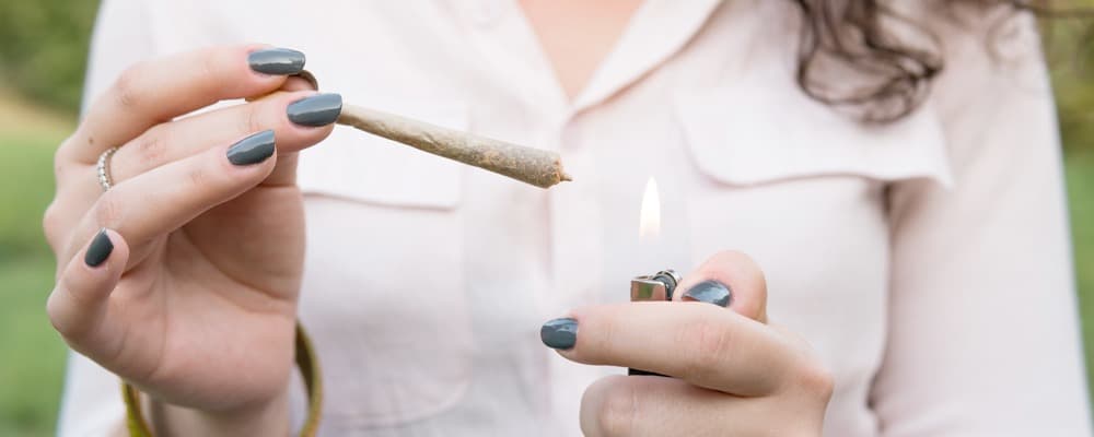 Young woman lighting up a cannabis preroll